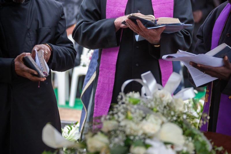 Priest praying in burial service