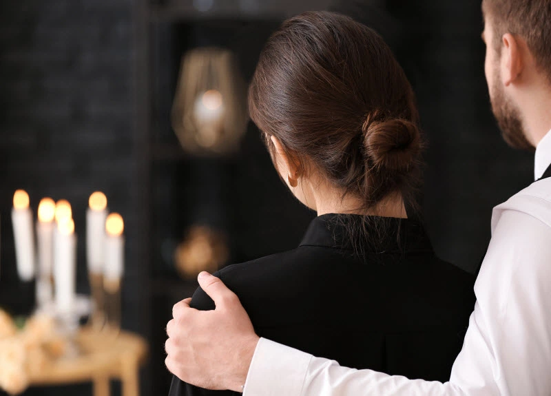 Man comforting his partner in the burial